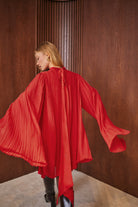 SERAFINE Elbise - Kırmızı | SERAFINE elbise, piliseli dokusu ve pelerin kollarıyla modern bir siluet sunar. Kırmızı renkte, oversize kesimi ile rahat ve şık bir görünüm sağlar.